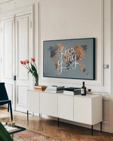 Keep Going World Map by Omar Escalante. shown as a framed stretched canvas in a living room above a console. Available as a archival giclee rolled canvas, fine art paper, or poster print. SKU 70407i.
