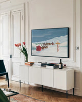 North Pole Christmas by Omar Escalante. shown as a framed stretched canvas in a living room above a console. Available as a archival giclee rolled canvas, fine art paper, or poster print. SKU 74907i.
