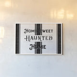Home Sweet Haunted Home BW by Pela Studio. shown as a paper print in a white frame. Available as a archival giclee rolled canvas, fine art paper, or poster print. SKU 68426i.
