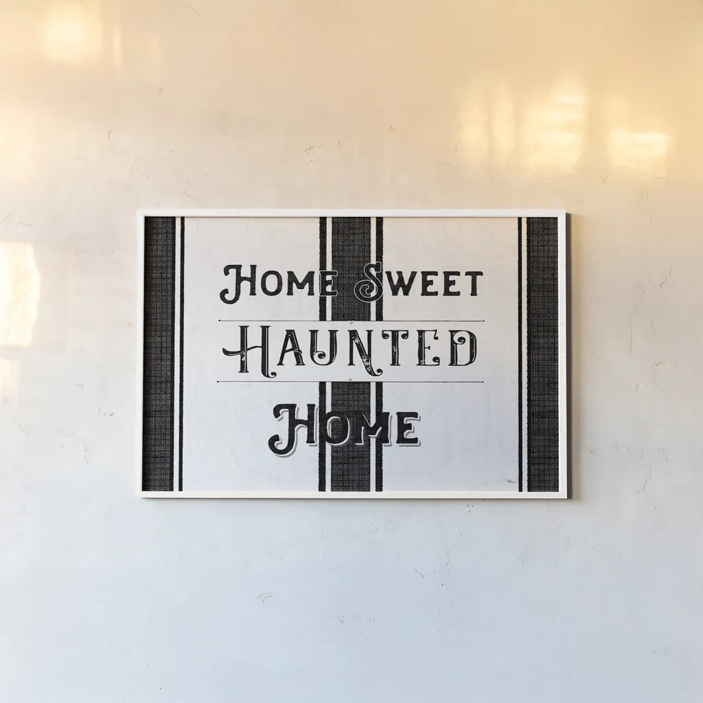 Home Sweet Haunted Home BW by Pela Studio. shown as a paper print in a white frame. Available as a archival giclee rolled canvas, fine art paper, or poster print. SKU 68426i.