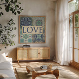Santorini I Love by Pela Studio. Shown in a natural wood frame in a cozy modern living room. Available as an archival giclee rolled canvas, fine art paper, or poster print. SKU 12150a.