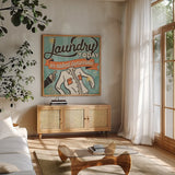 The Cleaners I by Pela Studio. Shown in a natural wood frame in a cozy modern living room. Available as an archival giclee rolled canvas, fine art paper, or poster print. SKU 14794a.