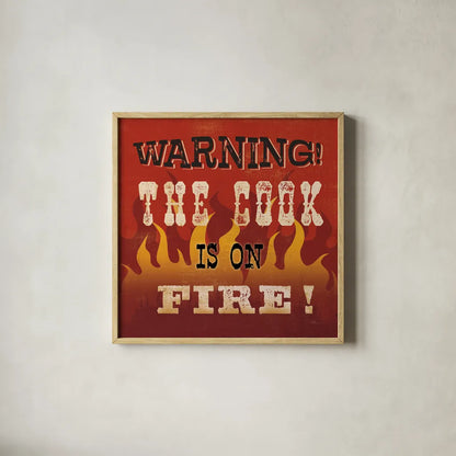 The Cook is On Fire by Pela Studio. Shown in a natural wood glass frame for a timeless modern aesthetic. Available as an archival giclee rolled canvas, fine art paper, or poster print. SKU 92148a.