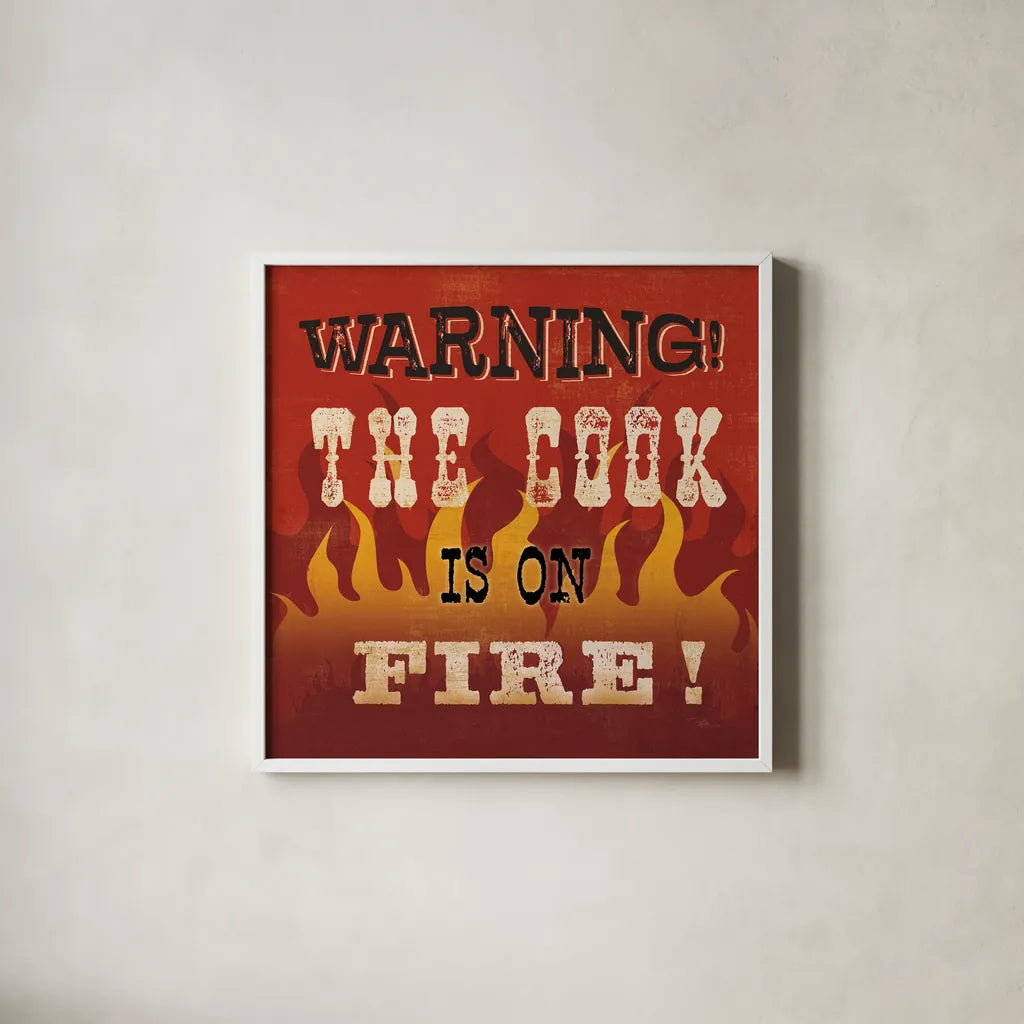 The Cook is On Fire by Pela Studio. Shown in a crisp white glass frame for a clean and minimalist style. Available as an archival giclee rolled canvas, fine art paper, or poster print. SKU 92148a.