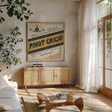 Wine Labels IV by Pela Studio. Shown in a natural wood frame in a cozy modern living room. Available as an archival giclee rolled canvas, fine art paper, or poster print. SKU 12862a.
