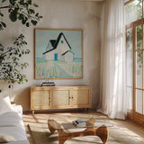 Cottage by the Sea by Phyllis Adams. Shown in a natural wood frame in a cozy modern living room. Available as an archival giclee rolled canvas, fine art paper, or poster print. SKU 27247a.