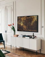 A Forest at Dawn with a Deer Hunt by Public Domain. shown as a framed stretched canvas in a living room above a console. Available as a archival giclee rolled canvas, fine art paper, or poster print. SKU 95528i.