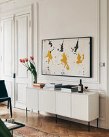 Abstract Background V Gold and Black by Roque Silva. shown as a framed stretched canvas in a living room above a console. Available as a archival giclee rolled canvas, fine art paper, or poster print. SKU 22752i.
