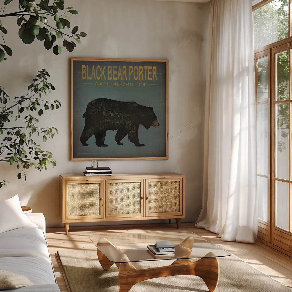 Black Bear Porter by Ryan Fowler. Shown in a natural wood frame in a cozy modern living room. Available as an archival giclee rolled canvas, fine art paper, or poster print. SKU 30843a.