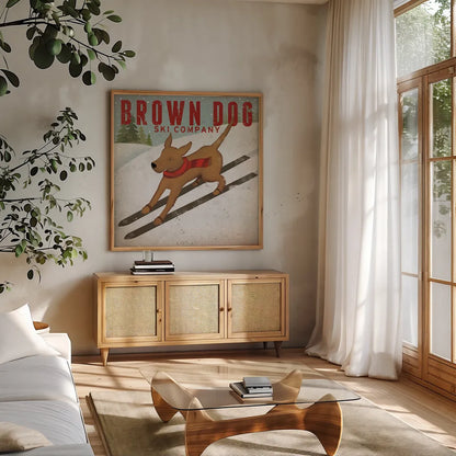 Brown Dog Ski Co by Ryan Fowler. Shown in a natural wood frame in a cozy modern living room. Available as an archival giclee rolled canvas, fine art paper, or poster print. SKU 17199a.