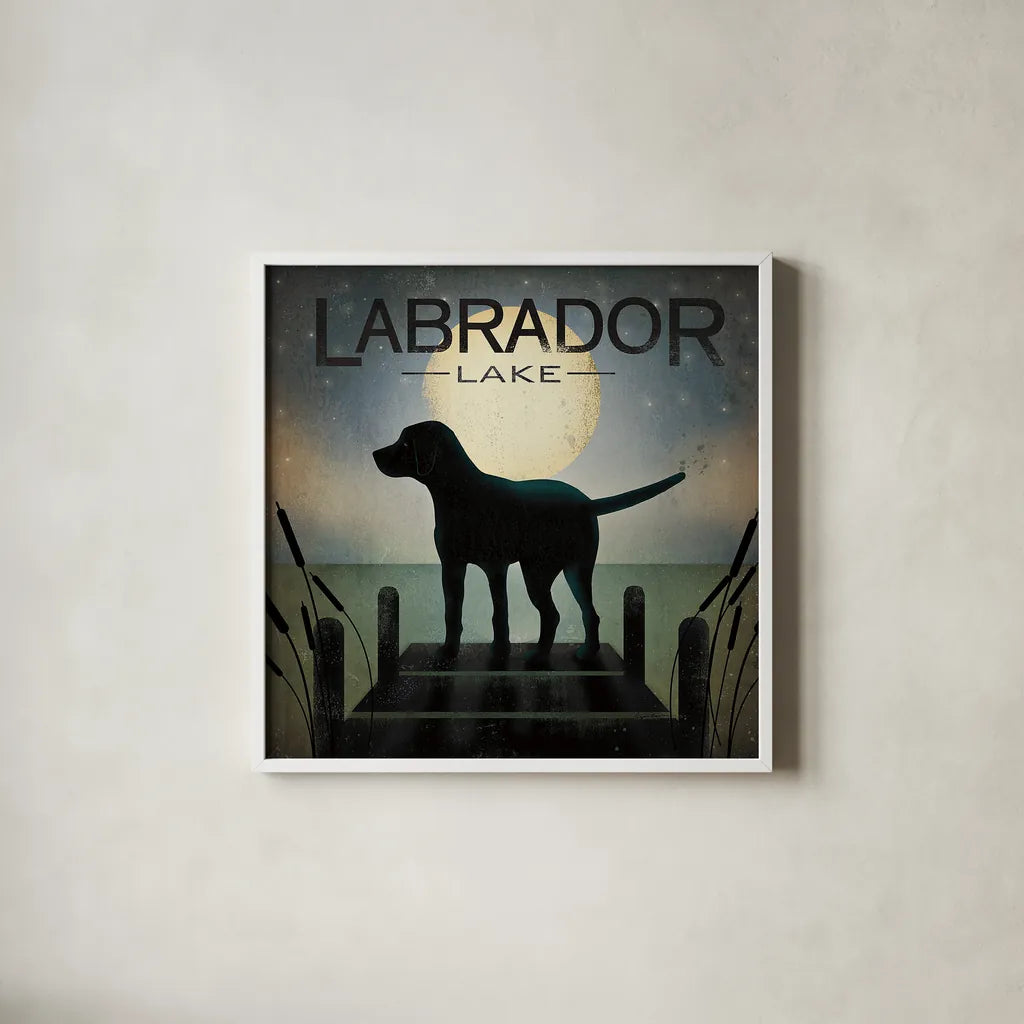 Moonrise Black Dog - Labrador Lake by Ryan Fowler. Shown in a crisp white glass frame for a clean and minimalist style. Available as an archival giclee rolled canvas, fine art paper, or poster print. SKU 11454a.