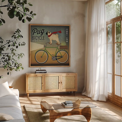Pug on a Bike by Ryan Fowler. Shown in a natural wood frame in a cozy modern living room. Available as an archival giclee rolled canvas, fine art paper, or poster print. SKU 17219a.