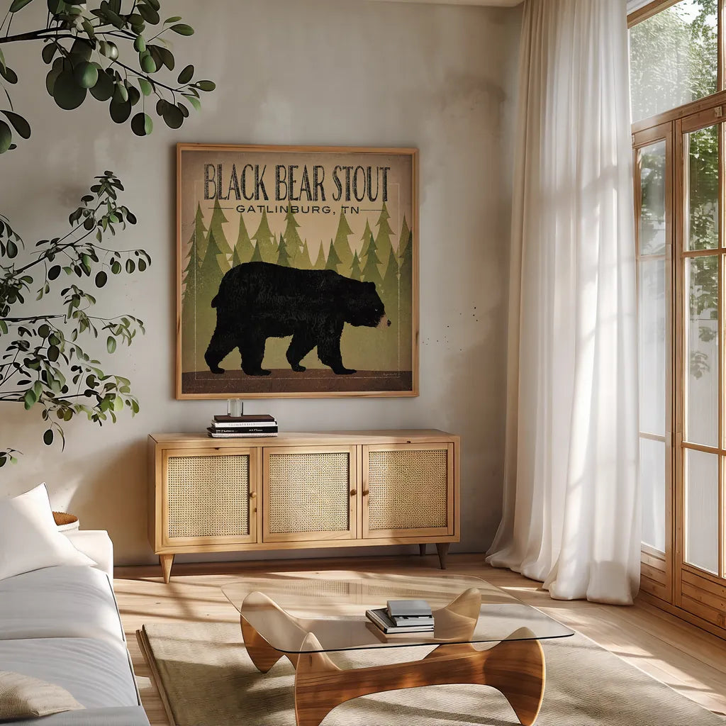 Take a Hike Bear Black Bear Stout by Ryan Fowler. Shown in a natural wood frame in a cozy modern living room. Available as an archival giclee rolled canvas, fine art paper, or poster print. SKU 30841a.