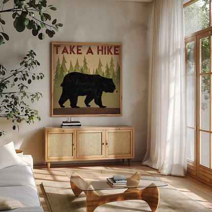 Take a Hike Black Bear by Ryan Fowler. Shown in a natural wood frame in a cozy modern living room. Available as an archival giclee rolled canvas, fine art paper, or poster print. SKU 22891a.