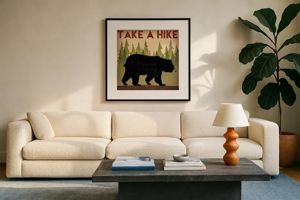 Take a Hike Black Bear by Ryan Fowler. Displayed in a glass frame with matte in a clean modern living room. Available as an archival giclee rolled canvas, fine art paper, or poster print. SKU 22891a.
