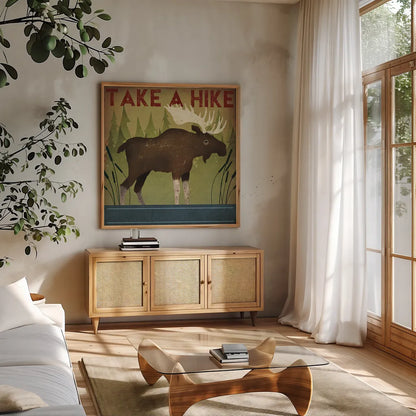 Take a Hike Moose by Ryan Fowler. Shown in a natural wood frame in a cozy modern living room. Available as an archival giclee rolled canvas, fine art paper, or poster print. SKU 22892a.