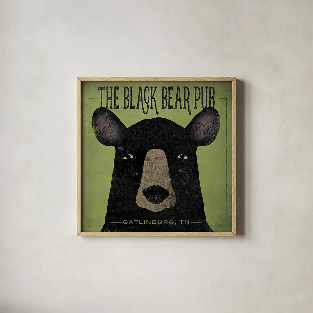 The Black Bear Pub by Ryan Fowler. Shown in a natural wood glass frame for a timeless modern aesthetic. Available as an archival giclee rolled canvas, fine art paper, or poster print. SKU 30842a.