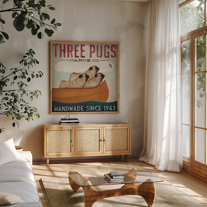 Three Pugs in a Canoe by Ryan Fowler. Shown in a natural wood frame in a cozy modern living room. Available as an archival giclee rolled canvas, fine art paper, or poster print. SKU 22336a.
