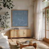 By the Beach V by Sarah Adams. Shown in a natural wood frame in a cozy modern living room. Available as an archival giclee rolled canvas, fine art paper, or poster print. SKU 83848a.