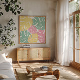 Monstera I Bright on White by Sarah Adams. Shown in a natural wood frame in a cozy modern living room. Available as an archival giclee rolled canvas, fine art paper, or poster print. SKU 33647a.