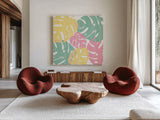 Monstera I Bright on White by Sarah Adams. Shown as extra-large giant wall art in a modern living room. Available as an archival giclee rolled canvas, fine art paper, or poster print. SKU 33647a.