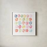 Watercolor Alphabet by Sarah Adams. Shown in a crisp white glass frame for a clean and minimalist style. Available as an archival giclee rolled canvas, fine art paper, or poster print. SKU 33404a.