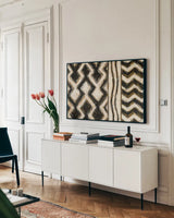 Black and Gold Geometric VIII by Shirley Novak. shown as a framed stretched canvas in a living room above a console. Available as a archival giclee rolled canvas, fine art paper, or poster print. SKU 25034i.