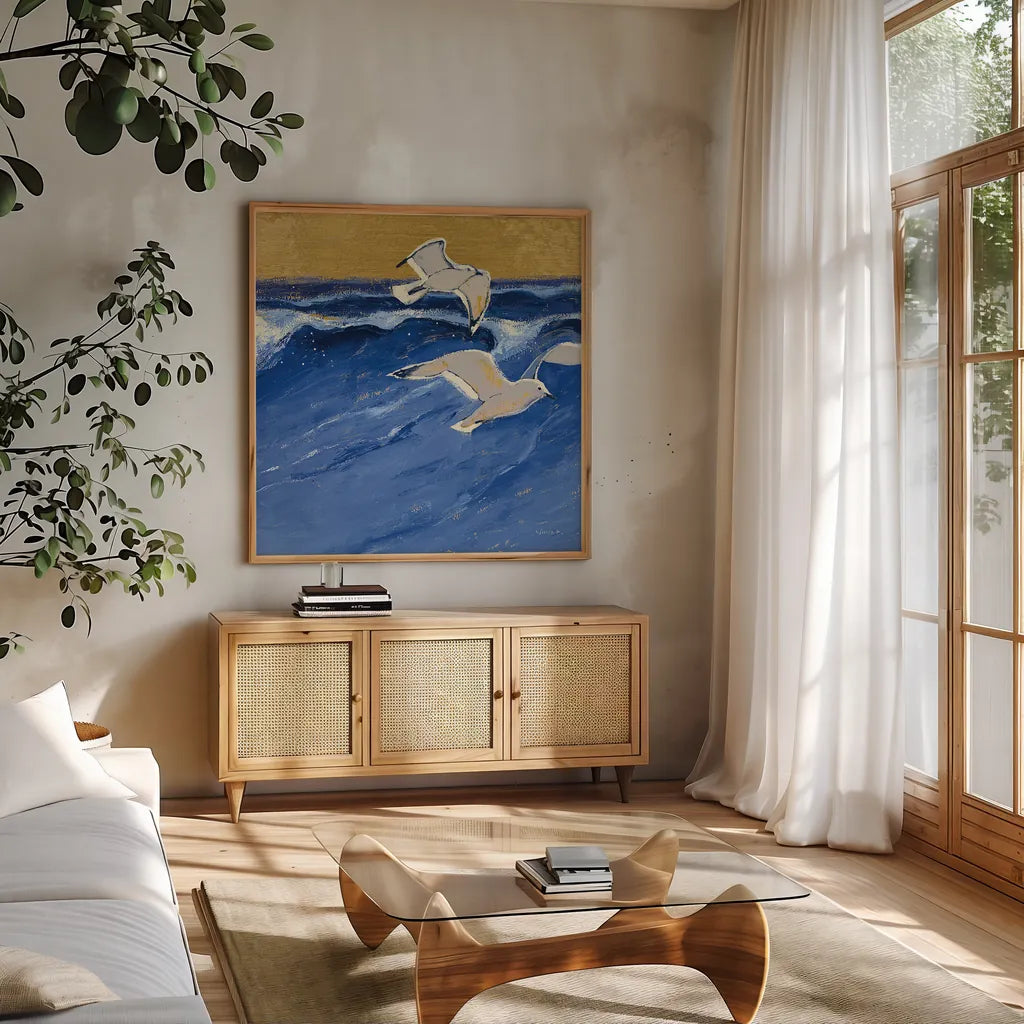 Seagulls with Gold Sky III by Shirley Novak. Shown in a natural wood frame in a cozy modern living room. Available as an archival giclee rolled canvas, fine art paper, or poster print. SKU 25258a.