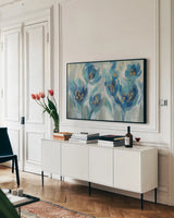 Blue Fairy Tale Floral III by Silvia Vassileva. shown as a framed stretched canvas in a living room above a console. Available as a archival giclee rolled canvas, fine art paper, or poster print. SKU 74394i.