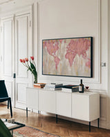 Blush World Map by Silvia Vassileva. shown as a framed stretched canvas in a living room above a console. Available as a archival giclee rolled canvas, fine art paper, or poster print. SKU 38248i.