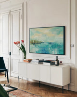 Cliff Side Town by Silvia Vassileva. shown as a framed stretched canvas in a living room above a console. Available as a archival giclee rolled canvas, fine art paper, or poster print. SKU 28118i.
