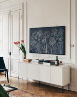 Indigo Floral I by Silvia Vassileva. shown as a framed stretched canvas in a living room above a console. Available as a archival giclee rolled canvas, fine art paper, or poster print. SKU 29153i.