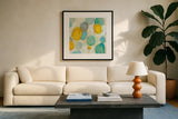 Painted Pebbles II by Silvia Vassileva. Displayed in a glass frame with matte in a clean modern living room. Available as an archival giclee rolled canvas, fine art paper, or poster print. SKU 22334a.