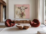 White Cow on Pink by Silvia Vassileva. Shown as extra-large giant wall art in a modern living room. Available as an archival giclee rolled canvas, fine art paper, or poster print. SKU 69171a.