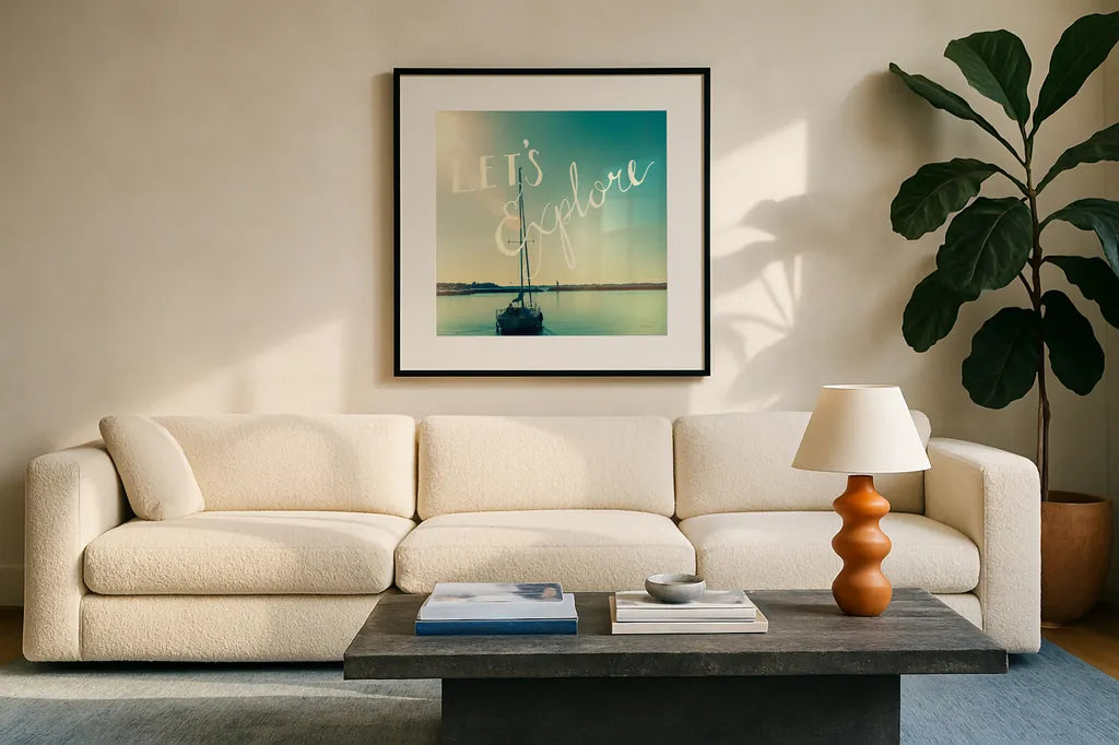 Coastline Sailboat Explore by Sue Schlabach. Displayed in a glass frame with matte in a clean modern living room. Available as an archival giclee rolled canvas, fine art paper, or poster print. SKU 15251a.