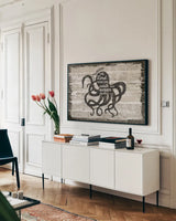 Driftwood Coast Scripture IV by Sue Schlabach. shown as a framed stretched canvas in a living room above a console. Available as a archival giclee rolled canvas, fine art paper, or poster print. SKU 48735i.
