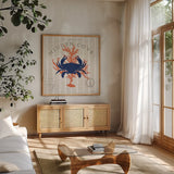 Island Findings II Crab by Sue Schlabach. Shown in a natural wood frame in a cozy modern living room. Available as an archival giclee rolled canvas, fine art paper, or poster print. SKU 15099a.