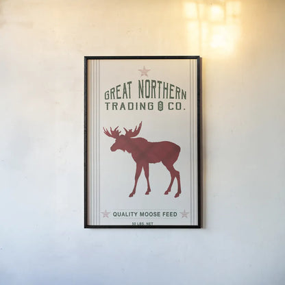 Northern Trading Moose Feed v2 by Sue Schlabach. shown as a paper print in a black flame. Available as a archival giclee rolled canvas, fine art paper, or poster print. SKU 65049h.
