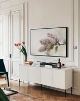 Pale Lilacs II by Sue Schlabach. shown as a framed stretched canvas in a living room above a console. Available as a archival giclee rolled canvas, fine art paper, or poster print. SKU 72130i.