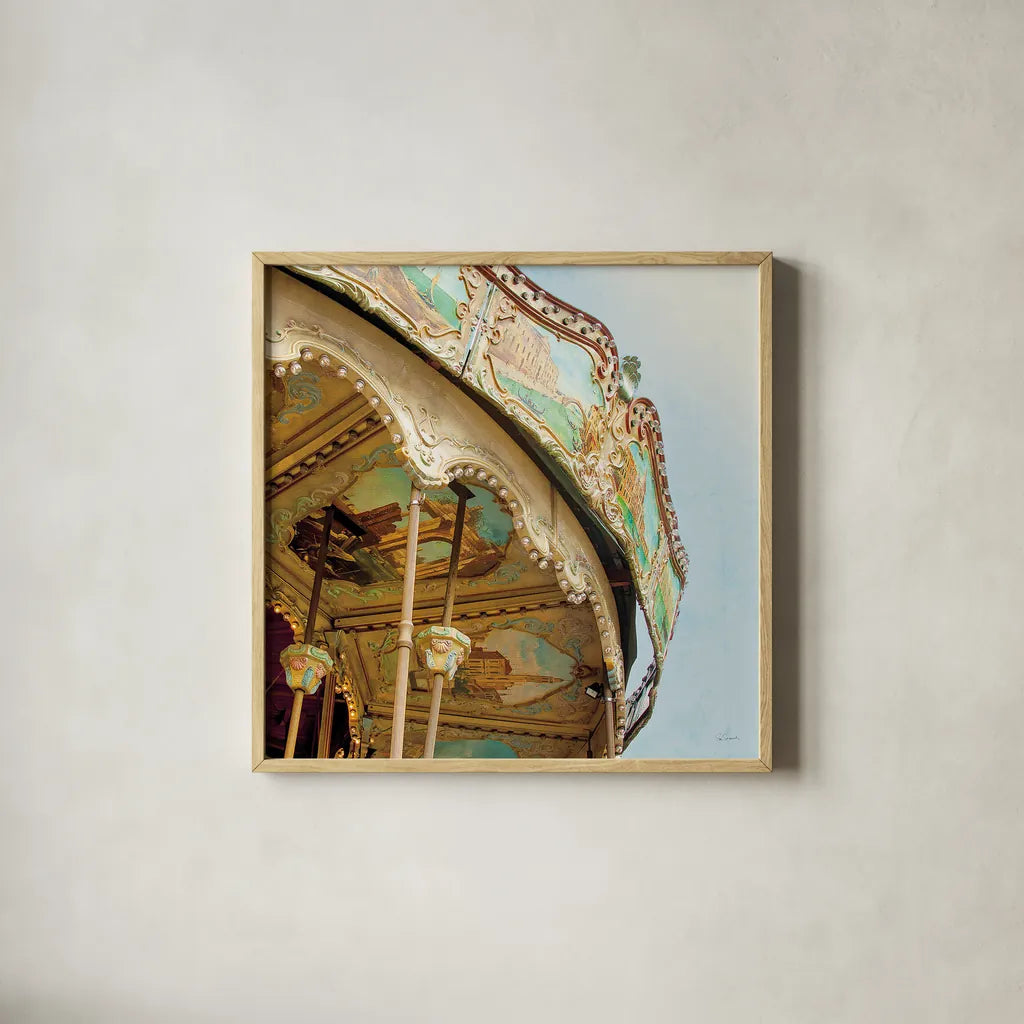 Paris Carousel I Aged by Sue Schlabach. Shown in a natural wood glass frame for a timeless modern aesthetic. Available as an archival giclee rolled canvas, fine art paper, or poster print. SKU 34160a.