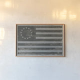 Slate American Flag by Sue Schlabach. shown as a paper print in a natural frame. Available as a archival giclee rolled canvas, fine art paper, or poster print. SKU 67594i.