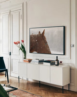 Snowy Caleb by Sue Schlabach. shown as a framed stretched canvas in a living room above a console. Available as a archival giclee rolled canvas, fine art paper, or poster print. SKU 60936i.