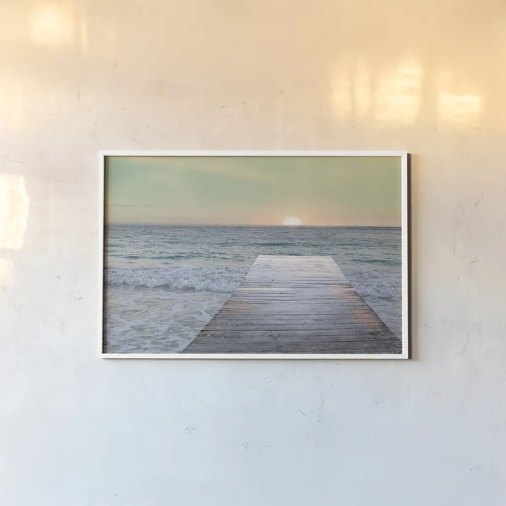 Sunrise Dock by Sue Schlabach. shown as a paper print in a white frame. Available as a archival giclee rolled canvas, fine art paper, or poster print. SKU 18852i.