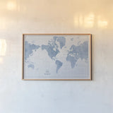 World Map White and Blue by Sue Schlabach. shown as a paper print in a natural frame. Available as a archival giclee rolled canvas, fine art paper, or poster print. SKU 48172i.