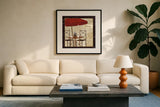 Petit Cafe II with Border by Veronique Charron. Displayed in a glass frame with matte in a clean modern living room. Available as an archival giclee rolled canvas, fine art paper, or poster print. SKU 3286a.