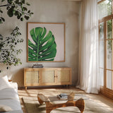 Statement Palms IV by Wellington Studio. Shown in a natural wood frame in a cozy modern living room. Available as an archival giclee rolled canvas, fine art paper, or poster print. SKU 33613a.