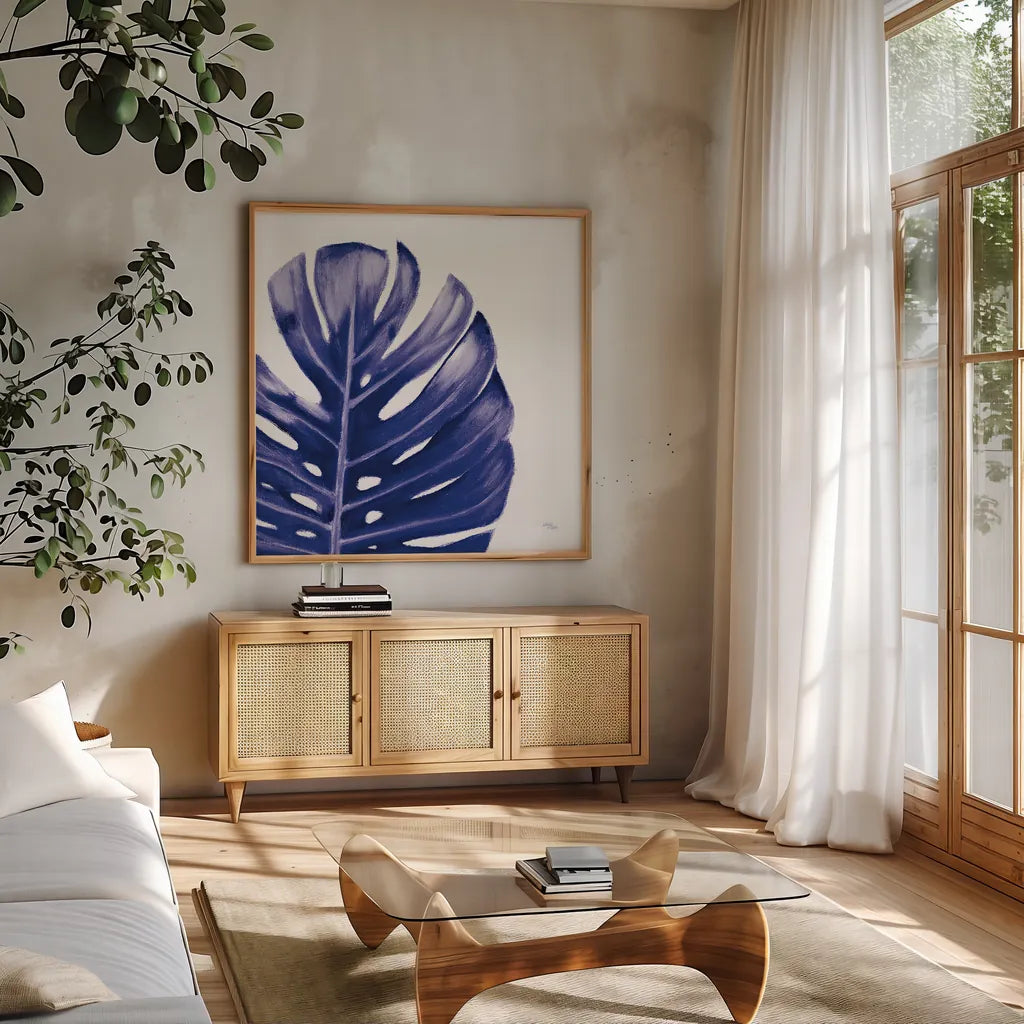 Statement Palms IV Indigo by Wellington Studio. Shown in a natural wood frame in a cozy modern living room. Available as an archival giclee rolled canvas, fine art paper, or poster print. SKU 34076a.