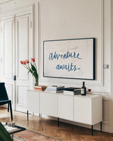 Adventure Awaits v2 by Wild Apple Portfolio. shown as a framed stretched canvas in a living room above a console. Available as a archival giclee rolled canvas, fine art paper, or poster print. SKU 37423i.