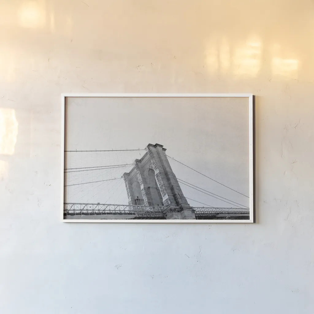 Brooklyn Bridge From Below by Wild Apple Portfolio. shown as a paper print in a white frame. Available as a archival giclee rolled canvas, fine art paper, or poster print. SKU 67630i.