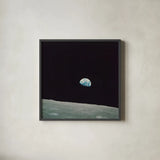 First Earth Rise by Wild Apple Portfolio. Shown in a sleek black glass frame for a contemporary gallery look. Available as an archival giclee rolled canvas, fine art paper, or poster print. SKU 84536a.